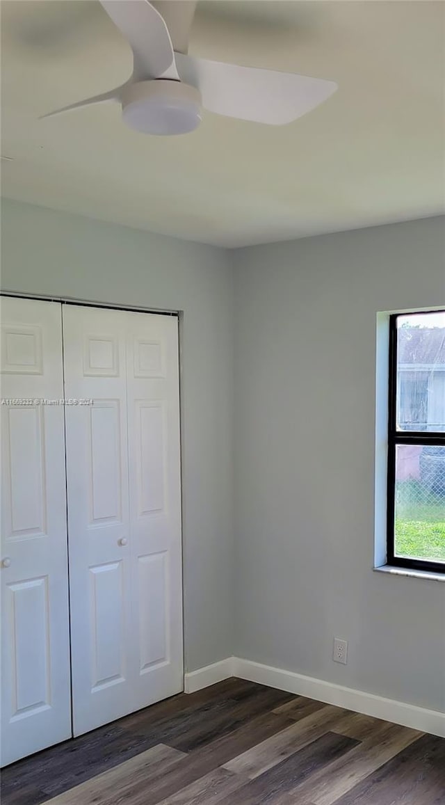 unfurnished bedroom with dark hardwood / wood-style flooring and a closet