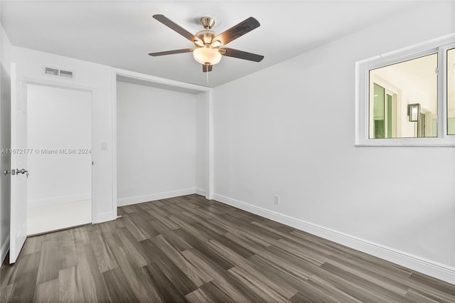 empty room with ceiling fan and dark wood-type flooring