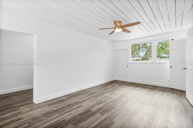 empty room featuring ceiling fan, wooden ceiling, and dark hardwood / wood-style floors