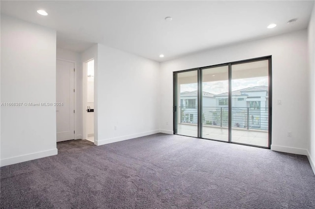 spare room featuring dark colored carpet