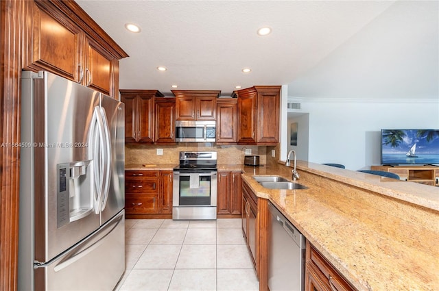 kitchen featuring light stone countertops, stainless steel appliances, decorative backsplash, and sink