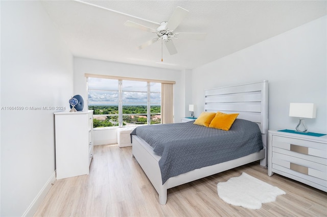 bedroom with light hardwood / wood-style flooring, ceiling fan, and a textured ceiling