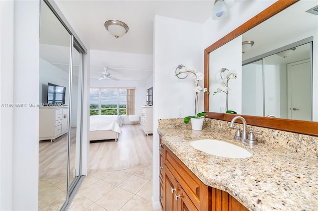 bathroom with ceiling fan, vanity, an enclosed shower, and hardwood / wood-style flooring