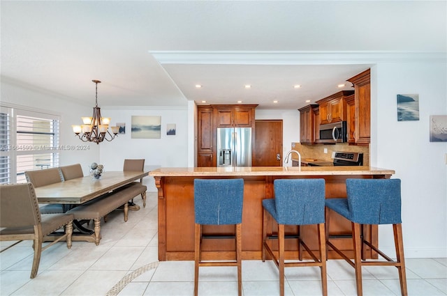 kitchen with crown molding, kitchen peninsula, stainless steel appliances, and tasteful backsplash