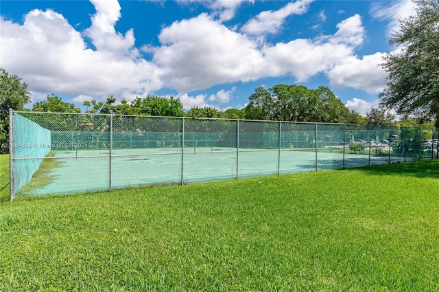 view of sport court featuring a lawn