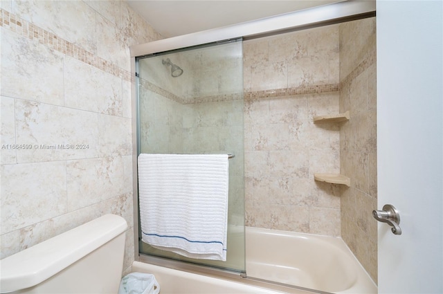 bathroom featuring enclosed tub / shower combo and toilet