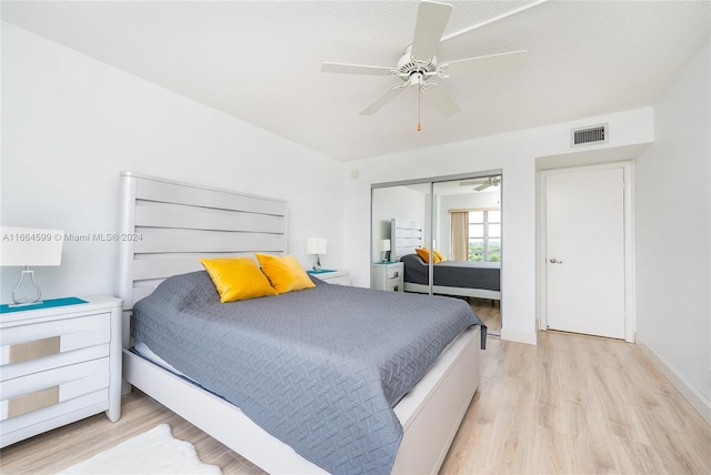 bedroom featuring ceiling fan, a textured ceiling, a closet, and light wood-type flooring