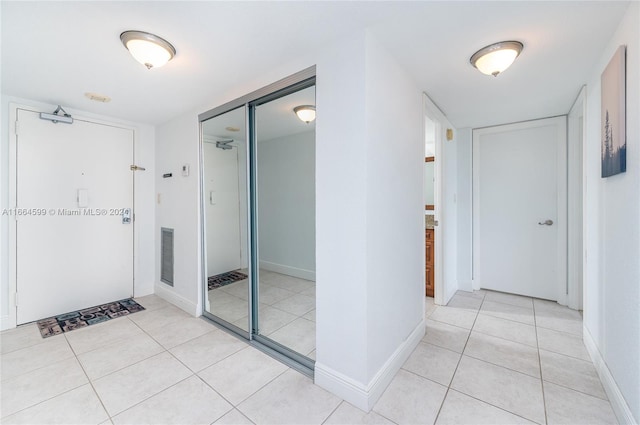 hall with light tile patterned floors