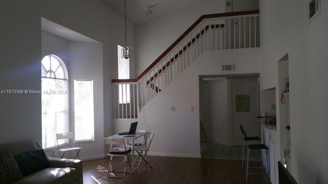 3204 Glenmoor Dr Unit 3204, West Palm Beach, FL 33409 - living area with high vaulted ceiling, wood finished floors, stairs, and baseboards