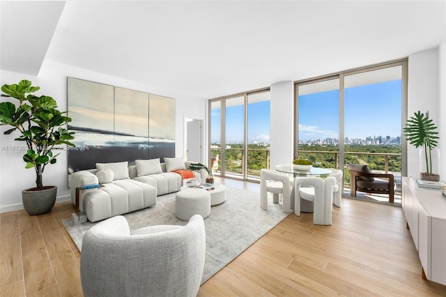 2678 Tigertail Ave Unit 1504B, Miami, FL 33133 - living room with a wall of windows, light wood-style floors, and a city view