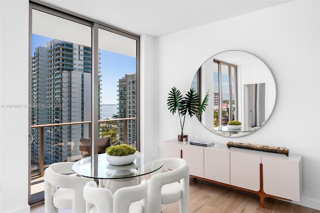2678 Tigertail Ave Unit 1504B, Miami, FL 33133 - dining room featuring light wood finished floors, a view of city, and a wall of windows