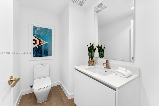 bathroom featuring hardwood / wood-style floors, vanity, and toilet