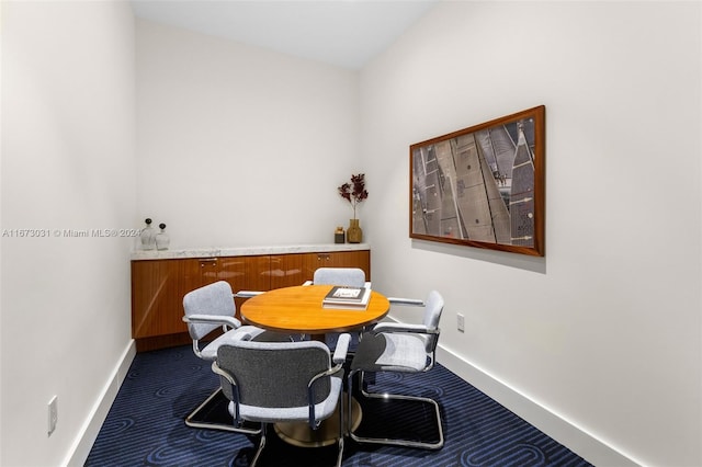 dining area featuring dark colored carpet