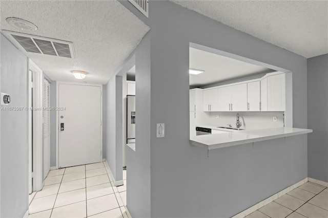 kitchen featuring kitchen peninsula, white cabinets, and a textured ceiling