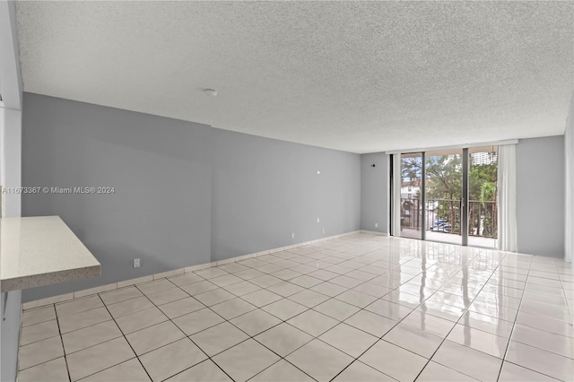 spare room with light tile patterned flooring and a textured ceiling