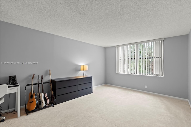 bedroom with light carpet and a textured ceiling