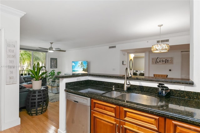 kitchen with pendant lighting, sink, dishwasher, dark stone countertops, and light wood-type flooring