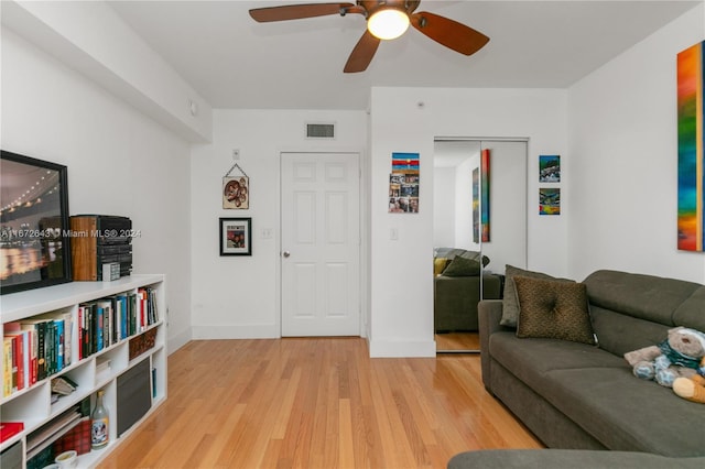 living room featuring light hardwood / wood-style floors and ceiling fan