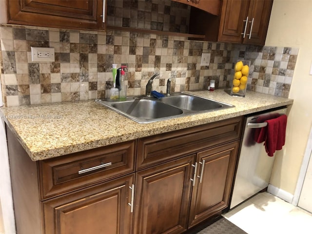 kitchen featuring dark brown cabinets, dishwasher, sink, and decorative backsplash