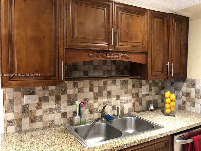 kitchen with decorative backsplash, dishwasher, and sink