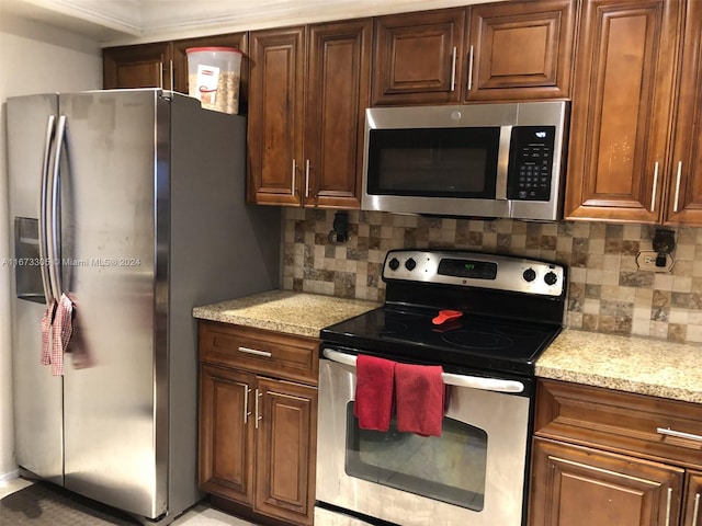 kitchen featuring light stone counters, appliances with stainless steel finishes, and backsplash