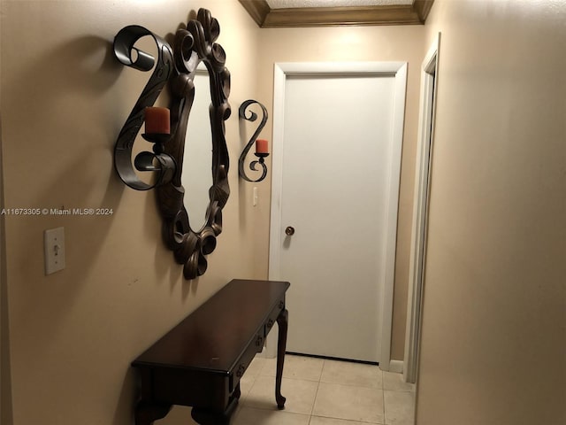 hall featuring light tile patterned flooring and crown molding