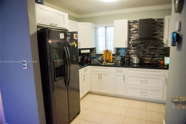 kitchen featuring black fridge, wall chimney exhaust hood, white cabinets, and decorative backsplash