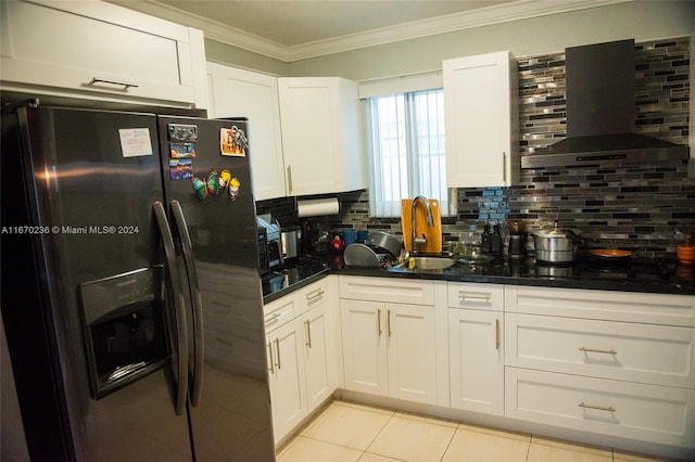 kitchen with tasteful backsplash, sink, white cabinets, wall chimney range hood, and stainless steel fridge