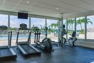 workout area with a drop ceiling and a healthy amount of sunlight