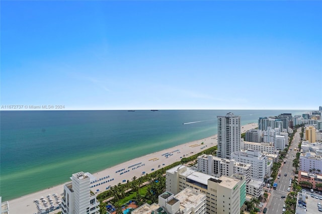 birds eye view of property featuring a water view and a beach view