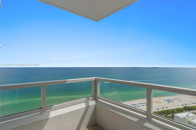 balcony with a water view and a beach view