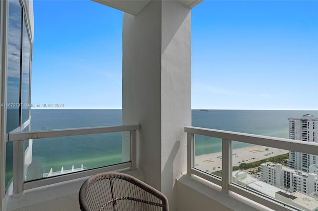 balcony featuring a view of the beach and a water view