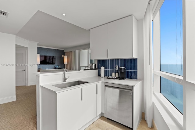 kitchen with kitchen peninsula, backsplash, white cabinetry, dishwasher, and sink