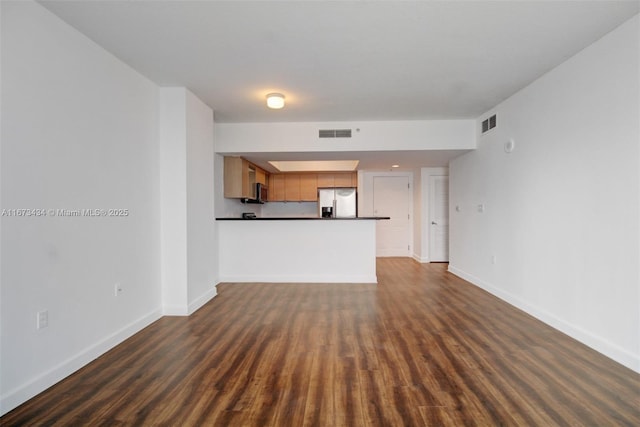 unfurnished living room with dark wood-type flooring