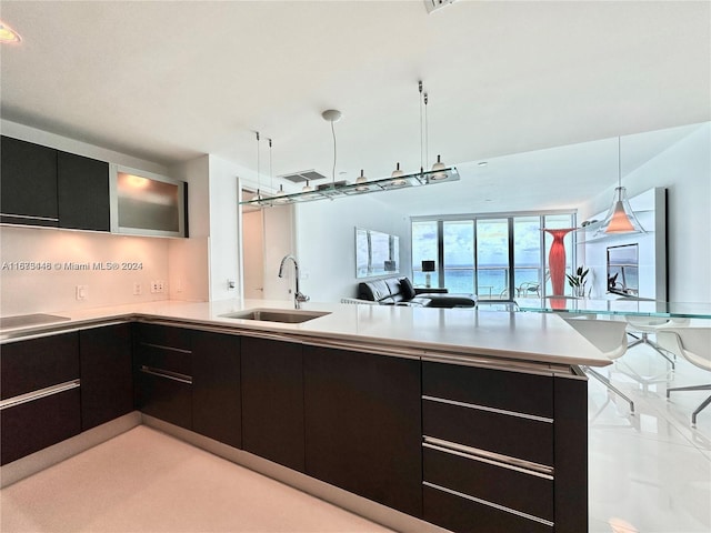 kitchen featuring pendant lighting, kitchen peninsula, and sink