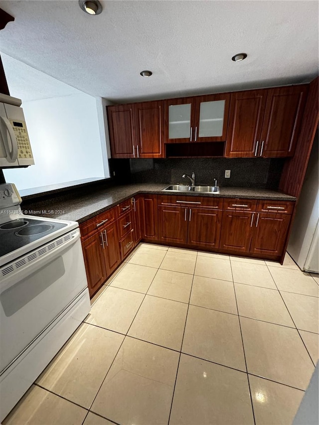 kitchen featuring light tile patterned flooring, sink, electric range, and tasteful backsplash