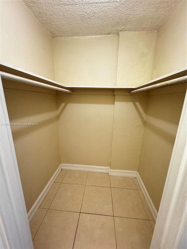 walk in closet with tile patterned floors