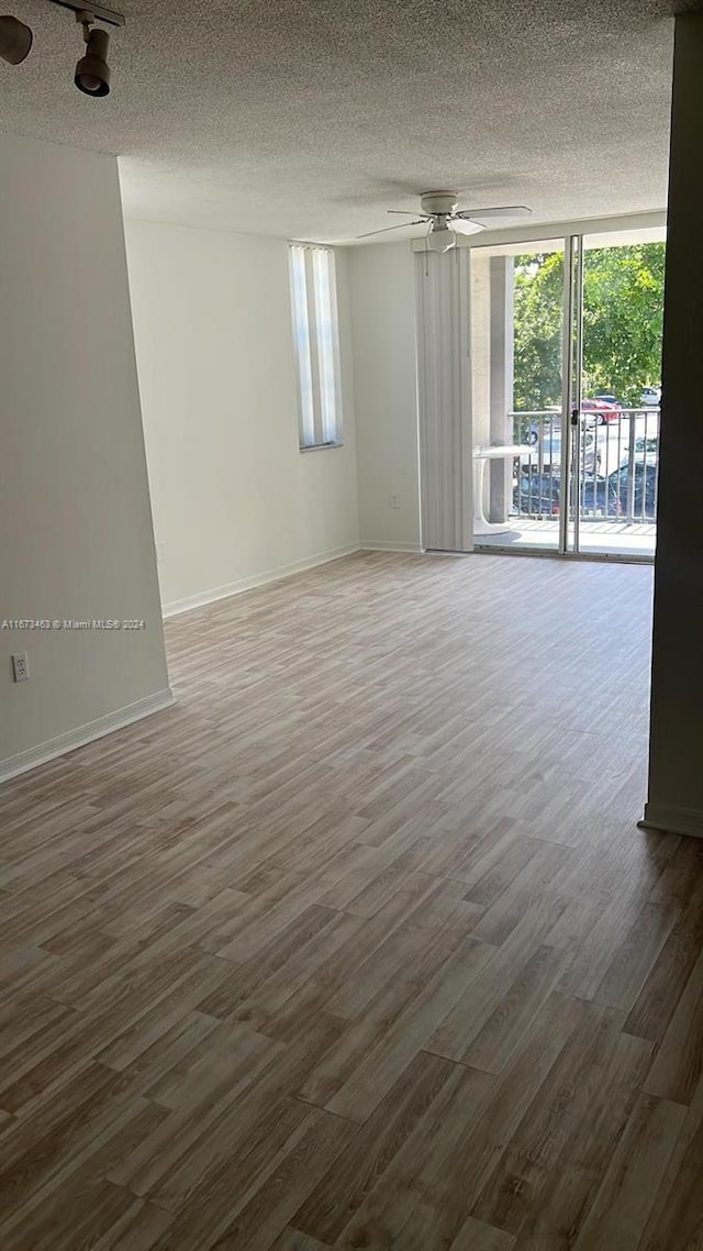 empty room featuring a textured ceiling, hardwood / wood-style flooring, and ceiling fan