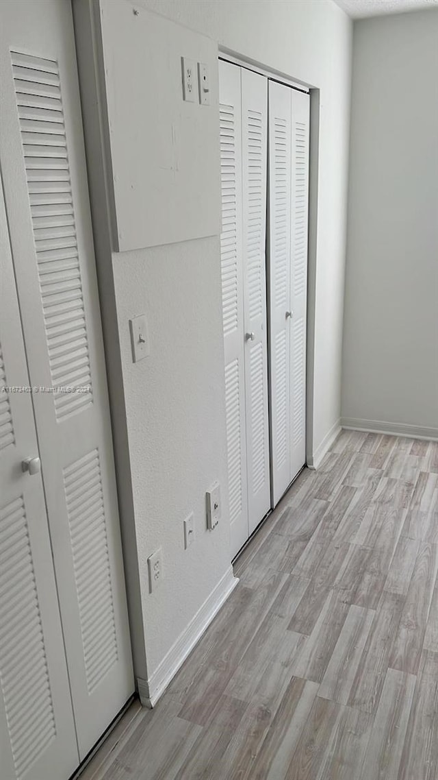 unfurnished bedroom with light hardwood / wood-style flooring and a closet