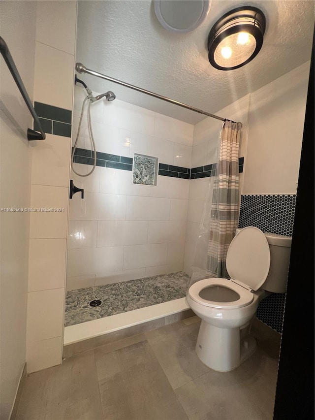 bathroom featuring walk in shower, a textured ceiling, tile patterned flooring, and toilet