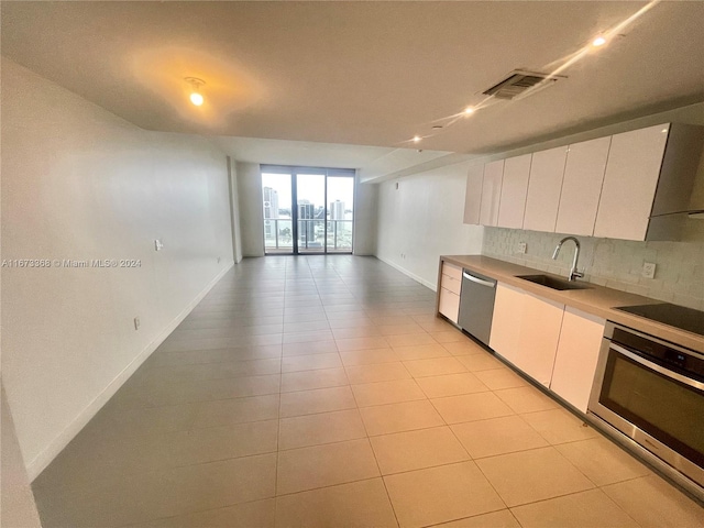 kitchen featuring stainless steel appliances, white cabinets, tasteful backsplash, and sink