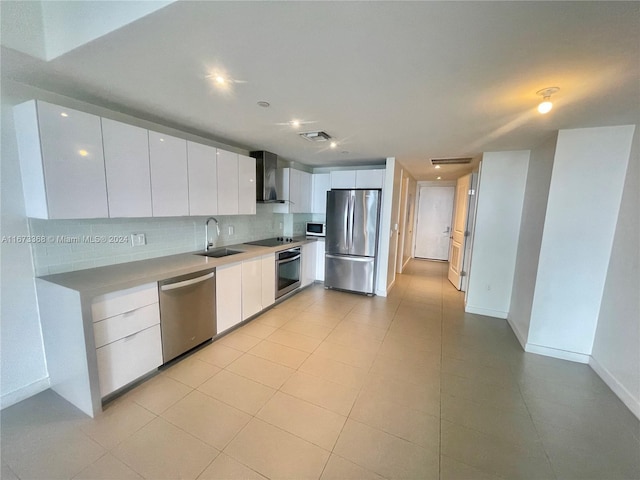 1600 NE 1st Ave Unit 2502, Miami, FL 33132 - kitchen featuring stainless steel appliances, wall chimney range hood, white cabinetry, and backsplash