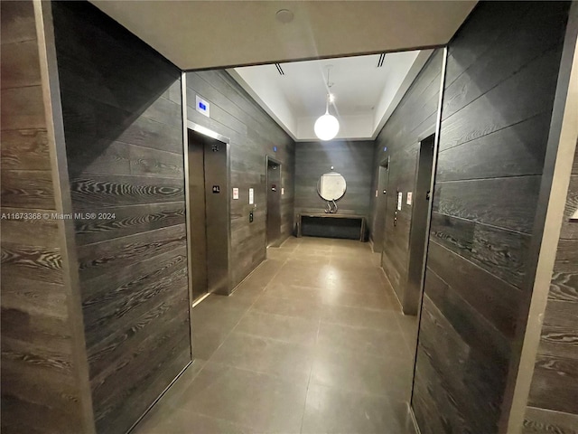 1600 NE 1st Ave Unit 2502, Miami, FL 33132 - hall featuring elevator, wood walls, and tile patterned flooring