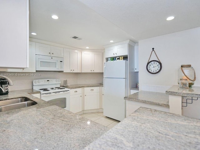 kitchen with white appliances, sink, light tile patterned floors, and white cabinets