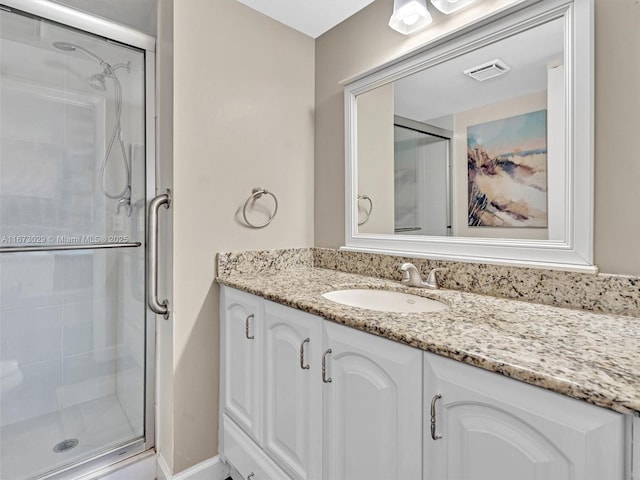 bathroom with vanity and a shower with shower door