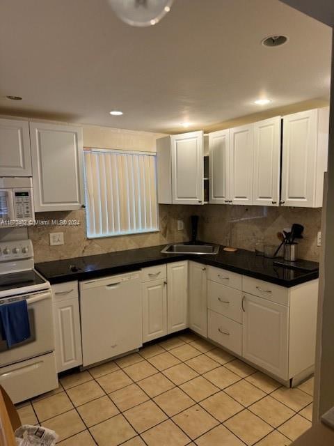 kitchen with decorative backsplash, white cabinetry, light tile patterned flooring, white appliances, and sink