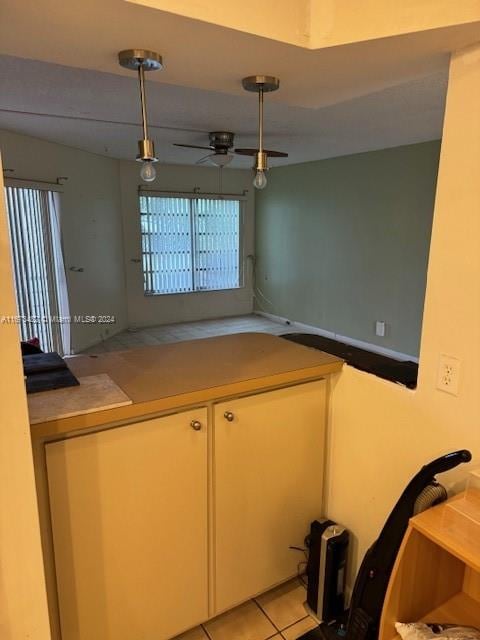 kitchen featuring ceiling fan, light tile patterned floors, and decorative light fixtures