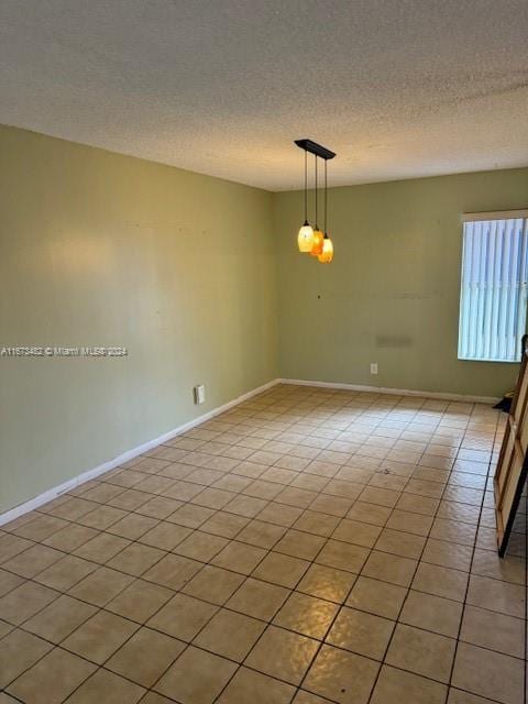 tiled empty room with a textured ceiling