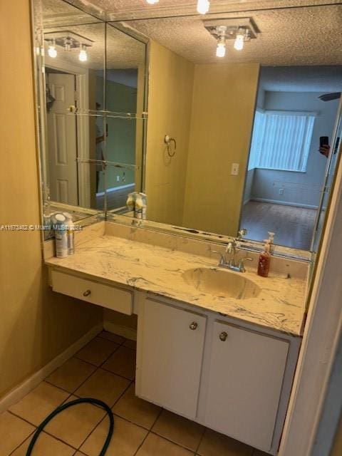 bathroom with tile patterned floors, a textured ceiling, and vanity