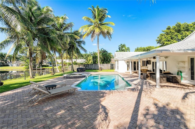 view of swimming pool featuring ceiling fan, a patio, a fenced backyard, french doors, and exterior kitchen